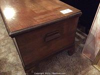 Three-quarter view of stained wood exterior showing beveled top and side handle.