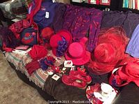 Wide view of assortment laid out on couch including hats, knitted gloves, slippers, scarves, and small accessory boxes