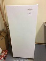 Front view of white upright freezer showing exterior condition and Wood's logo
