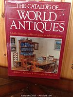 Front cover of The Catalog Of World Antiques book showing title, author, and an antique dining set photo