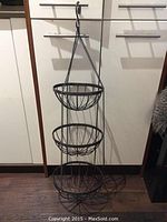 Front view of the 3 tier hanging fruit basket showing all three wire baskets attached by chains and the S-hook at top.