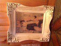 Photo of the entire framed vintage art print showing the distressed white gesso frame with ornate corner decorations.