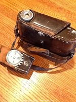 Close-up of vintage box camera in leather case, showing lens and controls