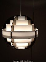 Close-up of front of illuminated stepped acrylic globe pendant lamp