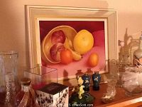 Overall display showing original framed fruit painting by J. Andrews surrounded by assorted clear glass vases, small blue porcelain vases, a figurine, and candle holders