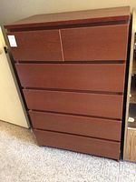 Front view of the wooden dresser showing all six drawers closed.