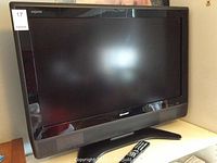 Front view of Sharp Aquos 37" LCD TV with remote placed in front