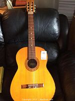 Front view of classical acoustic guitar showing body shape, strings, and rosette around sound hole.