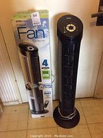 Photo of Seville Classic tower fan next to its box showing overall unit height and remote.