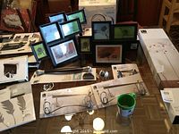 Photo of various Umbra brand black photo frames and metal wall-mounted racks with hooks, some displayed in packaging.