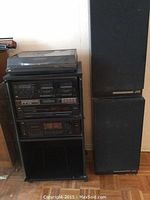 Full view of stereo components and speakers including turntable atop stack, double cassette decks, amplifier, CD player, and JVC speakers on floor.