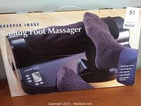 Box of Sharper Image Rolling Foot Massager showing front with product image and branding.