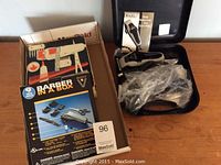 Three hair clipper kits including two Wahl brand kits and one Barber in a Box set, showing boxes and a black hard case with clipper and accessories packed.