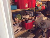 Shelf with Dremel 300 in box, nail containers, bottles, and red bins containing light bulbs and other small items