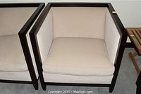 Frontal view of the beige upholstered Silva chair showing the cushion and dark wood frame.