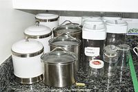 All items arranged on kitchen counter showing canisters, pots, jars, and plastic containers.
