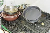 Overview of the set showing metal round pans stacked on a wire rack beside copper and other mixing bowls.