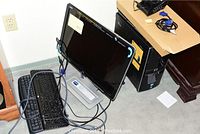 Overall view of HP monitor, tower, keyboards and cables on carpeted floor