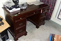 Full front and side view of dark brown Gibbard desk showing all drawers and overall condition