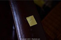 Close-up of right armrest showing leather patina and scuffs