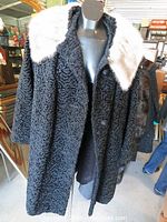 Front view of a black Persian lamb wool coat featuring a silver mink fur collar, length about 3/4 down the body, displayed on a mannequin.