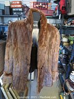 Front view of the coffee-colored fur jacket displayed on a mannequin, showing the overall style and length.