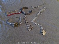 Overview photo showing all five bracelets and one necklace laid out on cloth surface.