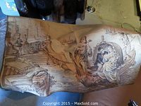 Full view of woven tapestry showing romantic boat scene including a man playing a string instrument and seated couple surrounded by floral garland on water.