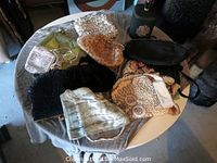 Overview of the assorted evening bags including beaded, silk, and embroidered styles on a round table.