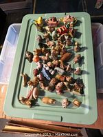 Overview of entire collection of Wade Red Rose Tea miniature figurines displayed on a green tray.