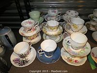 Shelved display of stacked floral bone china cups and saucers