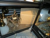 Hanging light fixture and 2 wall sconces displayed on a shelf, showing brass parts and white glass shades. Missing crystals evident on the hanging fixture.