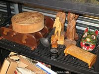Shelf with carved figures, carved box, wooden what-not case, and a painted wooden mask.