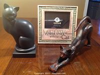 Three items included in the lot: stone 4x6 photo frame with cat text, black ceramic sitting cat figurine, black ceramic stretching cat figurine on wooden table.