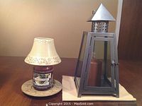 Yankee Christmas Pudding candle with ceramic shade and plate next to metal and glass candle holder on cloth.