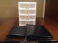 Photo of four-drawer plastic organizer along with two black vinyl day planners