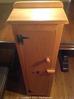 Front view of the wooden jelly cupboard with door closed showing knob and latch.