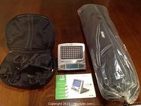 Photo of Apollo GoLITE light therapy device, black carrying case, user manual, and rolled yoga mat in packaging on wooden floor.