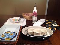 Full view of all items including casserole dishes, oil bottle, bread basket, oven mitts, and pedestal dish.