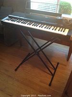 Full view of Yamaha YPR9 black electric keyboard on collapsible X-style stand, showing overall condition.
