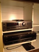 Photo of Technics SA-GX300 stereo receiver on top shelf with Sony 5-disc carousel CD player below, including two remote controls on the shelf.