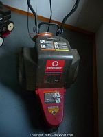 Top front angle view of Troy Bilt trimmer mower with model labels and warning stickers visible.