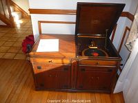 Front view of oak cabinet with hinged lid open showing turntable and front storage doors closed