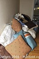 Image showing stacked assorted decorative pillows on floor and leaning against wall.