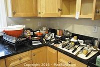 Photo showing assortment of kitchen utensils on countertop alongside Black & Decker indoor grill and WestBend slow cooker.