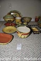 Full display of all 17 pieces showing a soup tureen, mixing bowls, custard cups, serving dishes, and a bread basket, arranged on carpet.