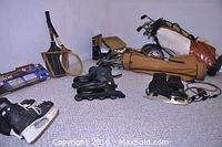 Full view of sporting equipment on floor showing tennis racquets, ice skates, roller blades, golf bags with clubs, and other gear