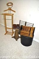 Wooden valet stand along with tie rack, pedestal, and additional accessories arranged on carpeted floor.