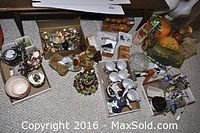 Assorted holiday decorations including Christmas, Halloween and spring themed pieces arranged in boxes and piles on a carpeted floor.