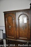 Front view of vintage secretary desk with two arched doors.